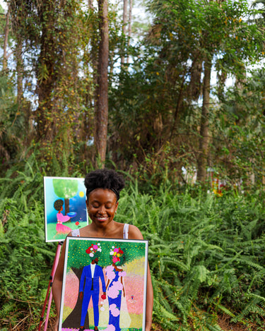 Black female artist Lori Saint Rome holding her floral Black love artwork
