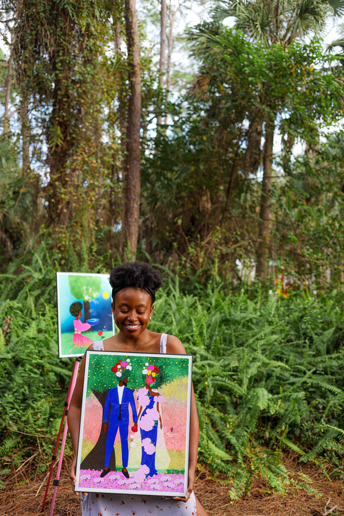 Black female artist Lori Saint Rome holding her floral Black love artwork