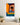 2026 calendar with a colorful illustration of a woman on a wall above a wooden shelf.